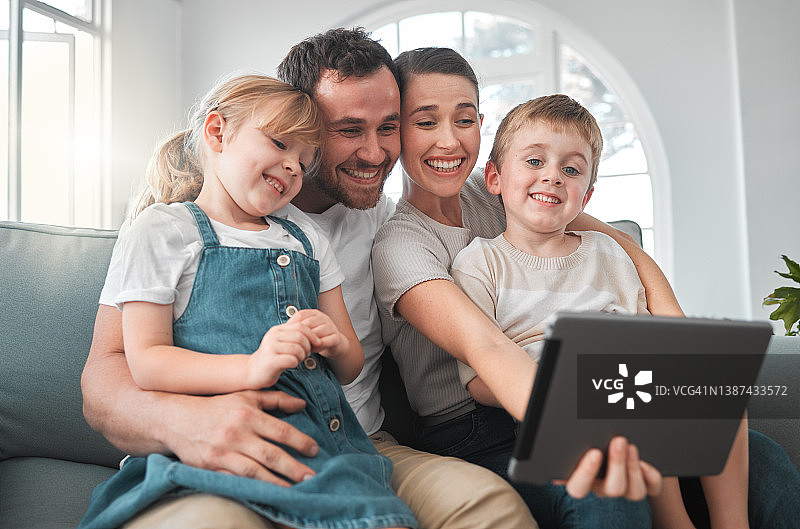 这张照片拍摄的是一个年轻的家庭在家里使用数码平板电脑图片素材