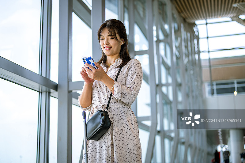 年轻的女商人用智能手机看着机场图片素材
