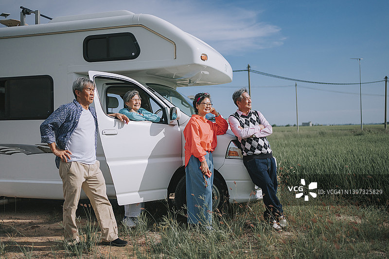 亚洲华人活跃的老年人享受风景水田前面的露营车房车家图片素材
