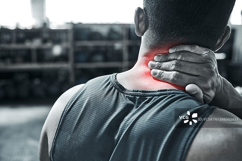 脖子疼痛会让任何一个健美运动员停下来。运动员的后背，脖子疼。颈部受伤是很严重的。健身有可能导致CGI红斑疼痛。一个男人的手在疼痛中摸着自己的脖子图片素材