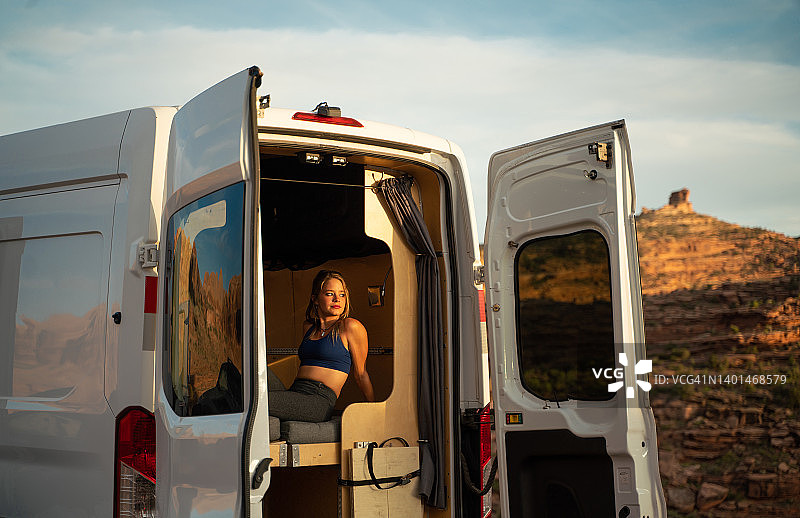 一个小女孩在犹他州摩押沙漠的一辆小货车里露营图片素材