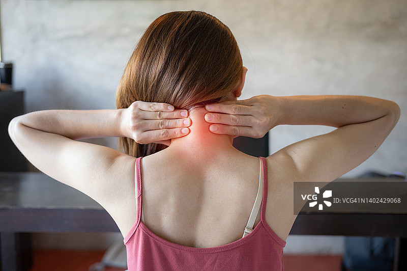 年轻女性颈部疼痛的后视图。图片素材