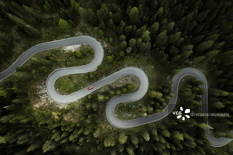 汽车行驶在森林中蜿蜒的山路上，俯视图图片素材