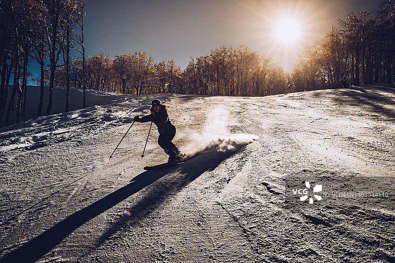 一位年轻女子正在享受滑雪下山的乐趣。图片素材