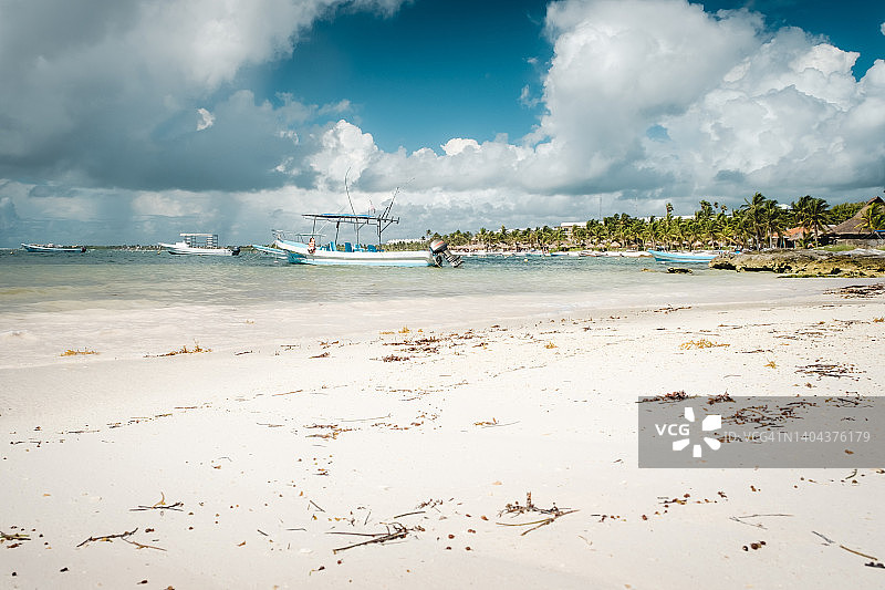 阿库马尔湾的木船。位于墨西哥湾加勒比海沿岸的天堂海滩阿库马尔。白色的沙滩，棕榈树和湛蓝清澈的水。墨西哥,里维埃拉玛雅图片素材