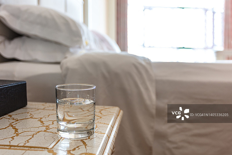 在豪华酒店房间的桌子上放着一杯水，经常喝水保持健康图片素材