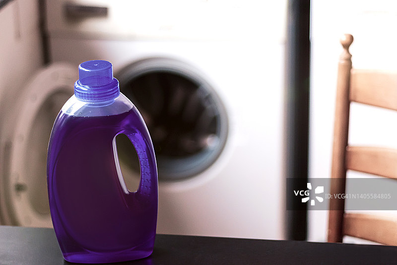 洗衣机前紫色洗衣液的特写。图片素材