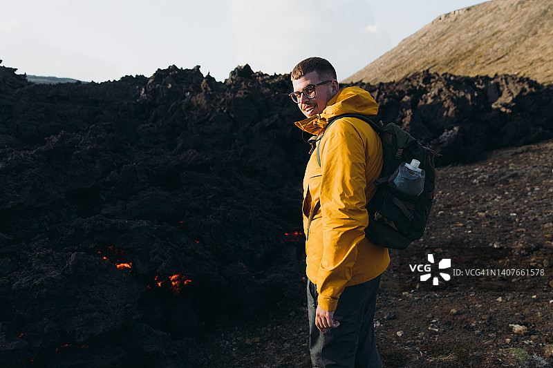 在冰岛Fagradalsfjall地区，男子旅行者探索具有新鲜熔岩的戏剧性火山景观图片素材