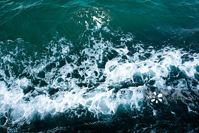 鸟瞰海浪在海洋中飞溅的浪花。碧波粼粼的海水。图片素材