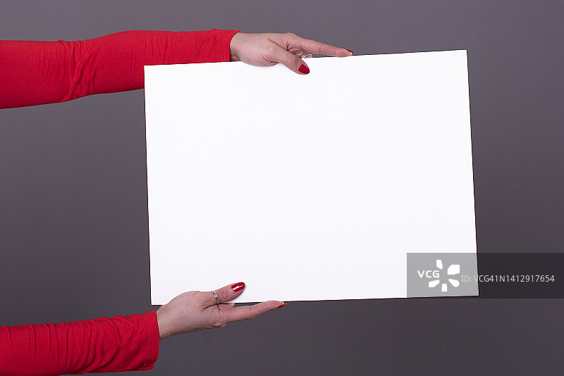 女性手里拿着一张空白的海报，用于复制空间和模型图片素材