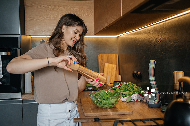 女人在厨房做蔬菜沙拉，营养适当图片素材