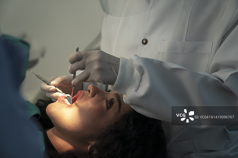 牙医正在检查病人的牙齿。图片素材