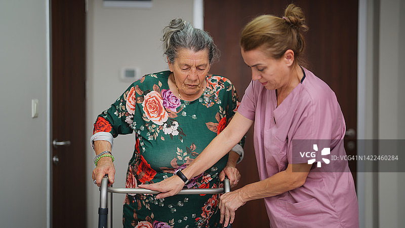 在医院病房协助老年病人行走的护士图片素材