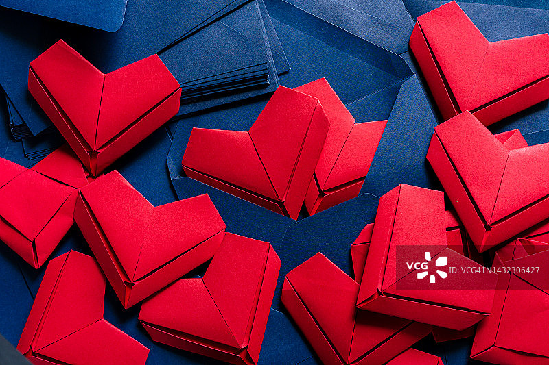 红纸心和蓝信封，情书的想法，蓝信封和红色的心溢出。图片素材