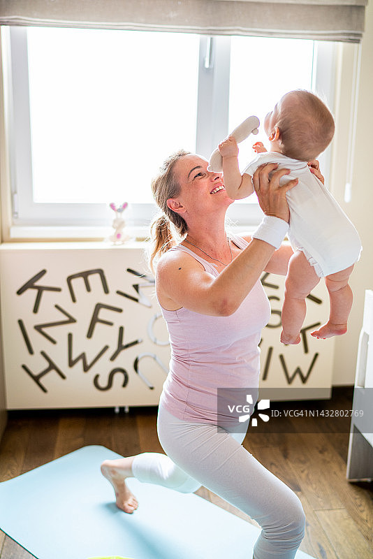 妇女在家抱着婴儿锻炼图片素材