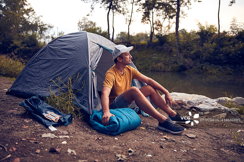人们在大自然中露营，在森林河边搭起帐篷过夜。图片素材