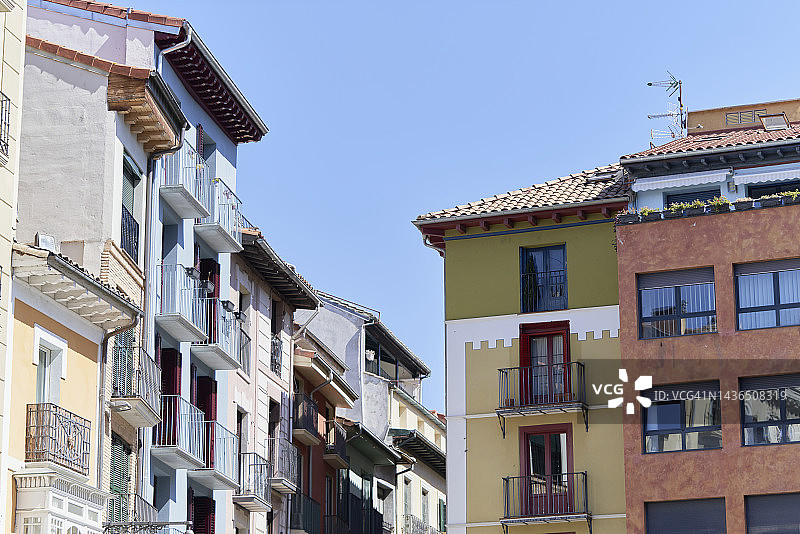 在阳光明媚的日子里，带有阳台和大窗户的马德里居民楼的外部图片素材
