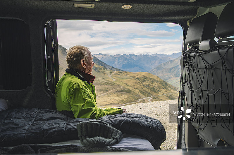 一只年长的雄性从他的露营车上欣赏山景图片素材