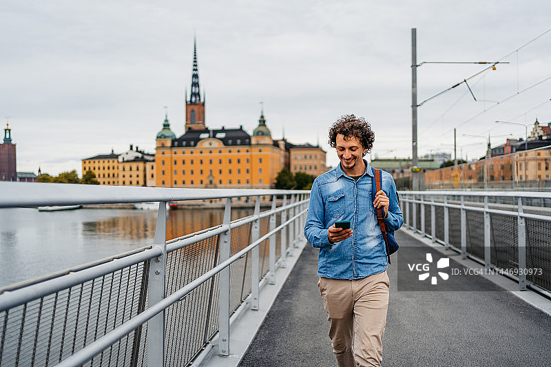 斯德哥尔摩大桥上用手机的年轻人图片素材