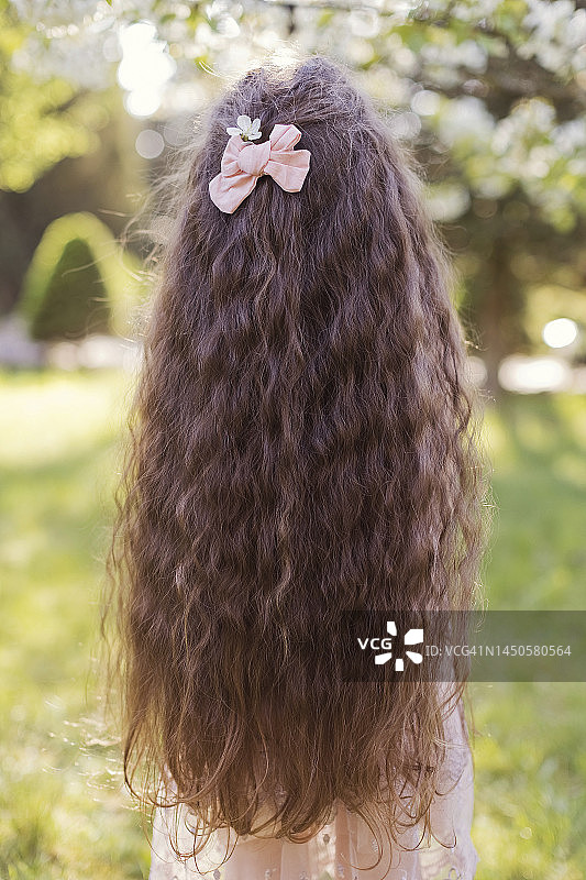 长波浪头发，戴粉红色蝴蝶结的女孩图片素材
