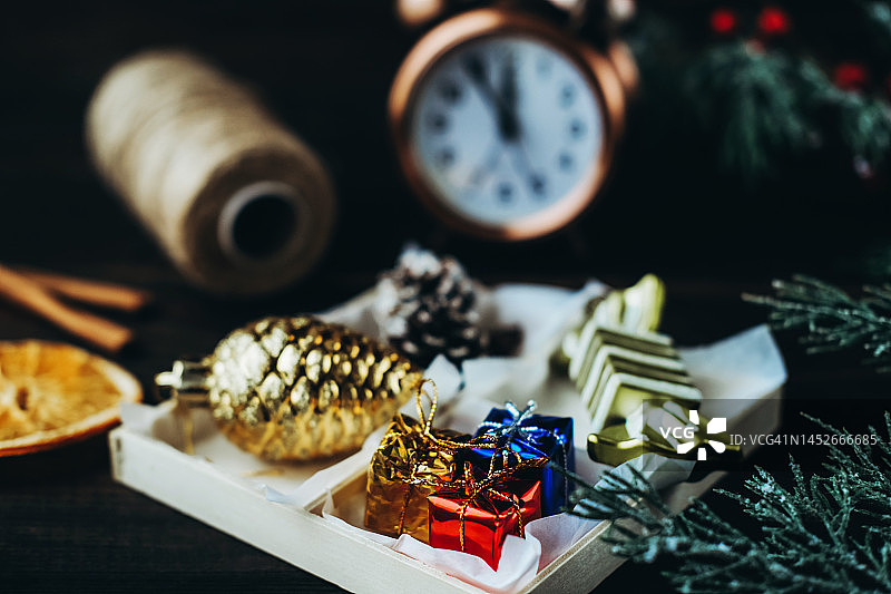 盒子里有圣诞玩具，串线，闹钟和冷杉树枝。图片素材