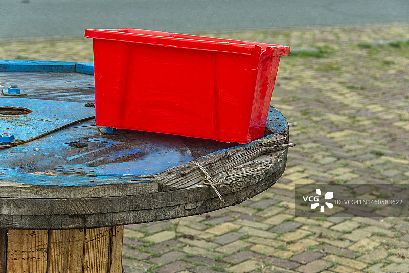 红色的塑料板条箱放在木制滑轮上图片素材