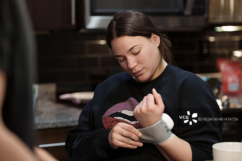 一位年轻的拉丁美洲妇女在家里用腕表测量血压图片素材