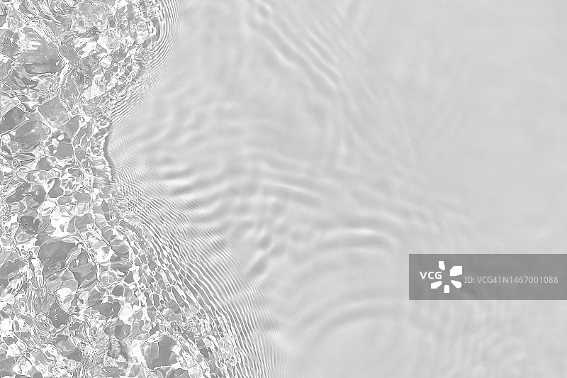 去饱和透明透明的水面纹理与涟漪，飞溅和波浪在阳光下图片素材