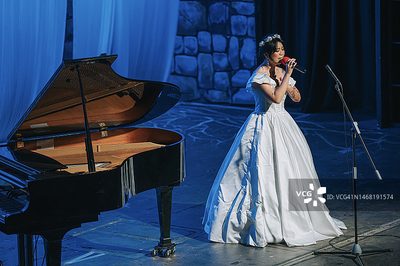 年轻的中国戏曲女歌唱家与钢琴家在台上独唱图片素材