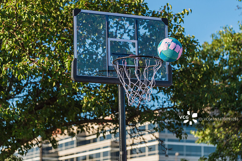 在操场或球场上被射向篮球框后在空中打篮球图片素材