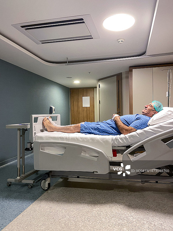病人准备做手术。在病房里，成熟的男人躺在病床上等待手术图片素材