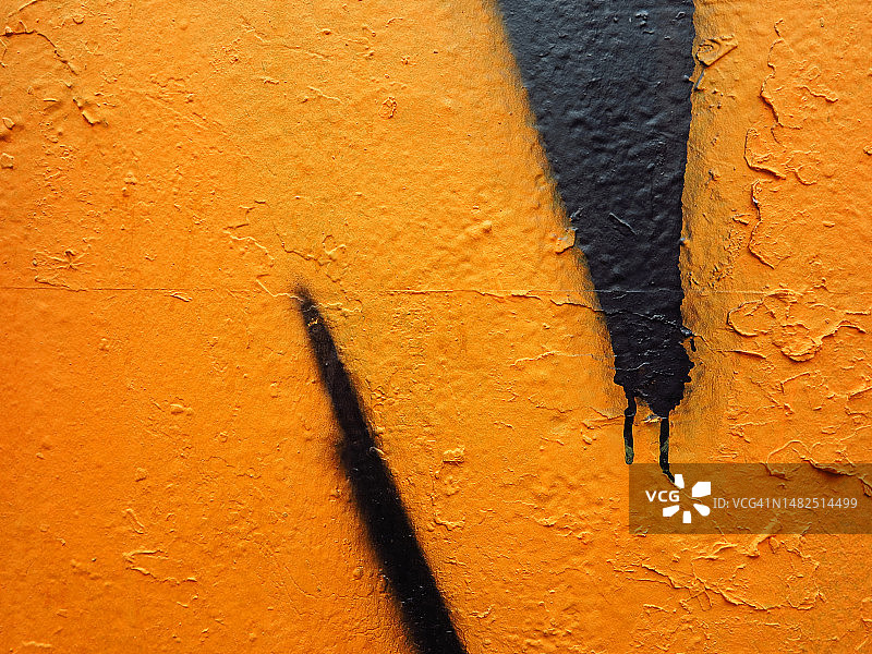 法国巴黎，黑色和黄色的油漆涂在有纹理的混凝土墙上图片素材