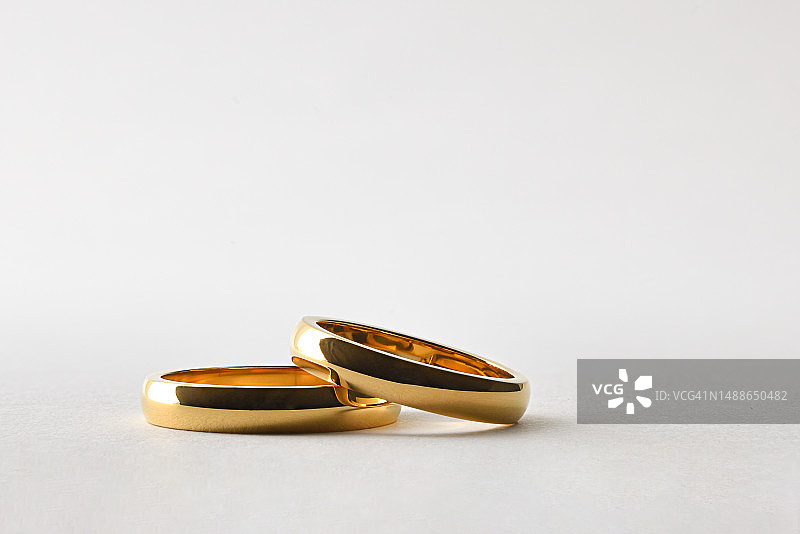 金色的结婚戒指躺在白色孤立的背景，西班牙图片素材