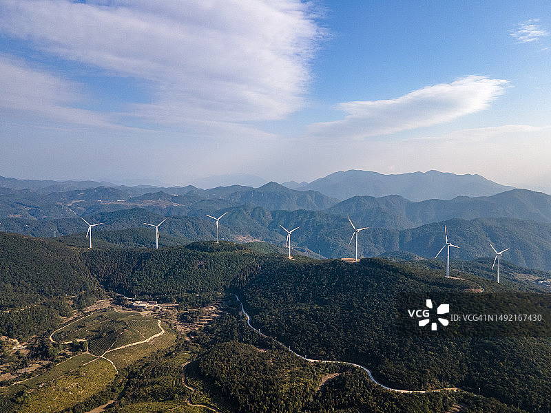 阳光明媚的山上的风力涡轮机鸟瞰图图片素材