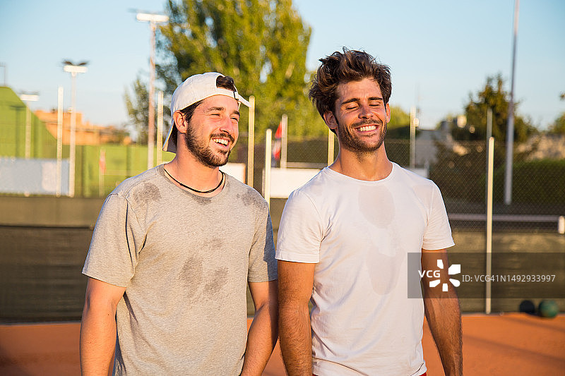 西班牙马德里，两个男人在网球场上大笑图片素材