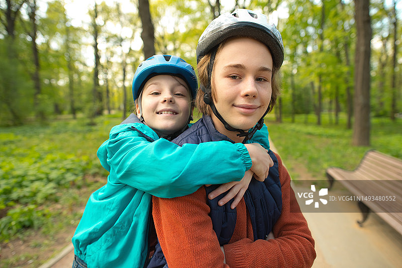 夏季公园里的孩子们准备滑旱冰，骑滑板车或自行车图片素材