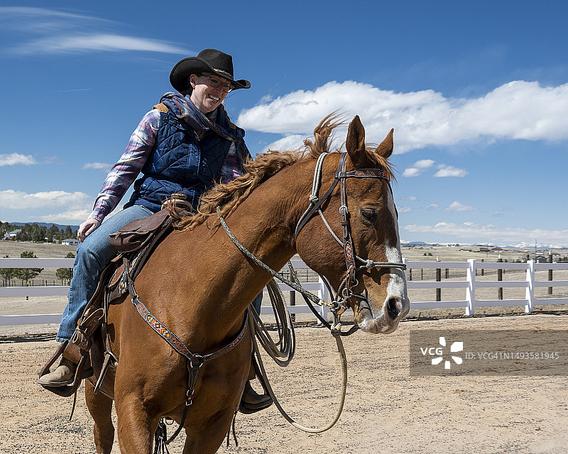 美国科罗拉多州，科罗拉多斯普林斯，年轻的女牛仔在竞技场上骑马图片素材