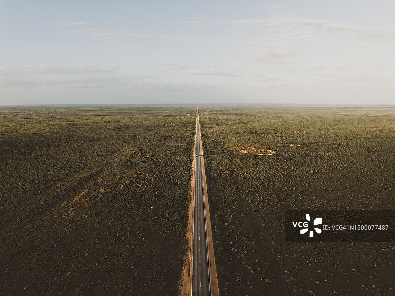 从空中拍摄的日落，车辆行驶在艾尔高速公路上穿过纳拉伯平原，澳大利亚南澳大利亚图片素材