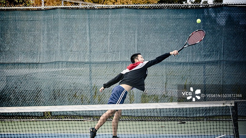 一名男子在球场上伸手去拿网球图片素材