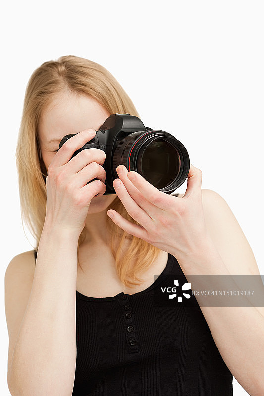年轻女子拿着照相机瞄准图片素材