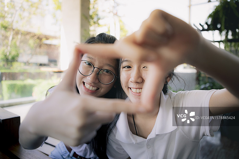 泰国，两个亚洲少年在相框上签名，背后是幸福的脸图片素材
