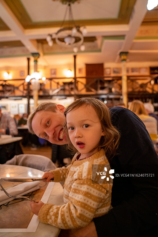 父亲和孩子在餐馆吃饭图片素材