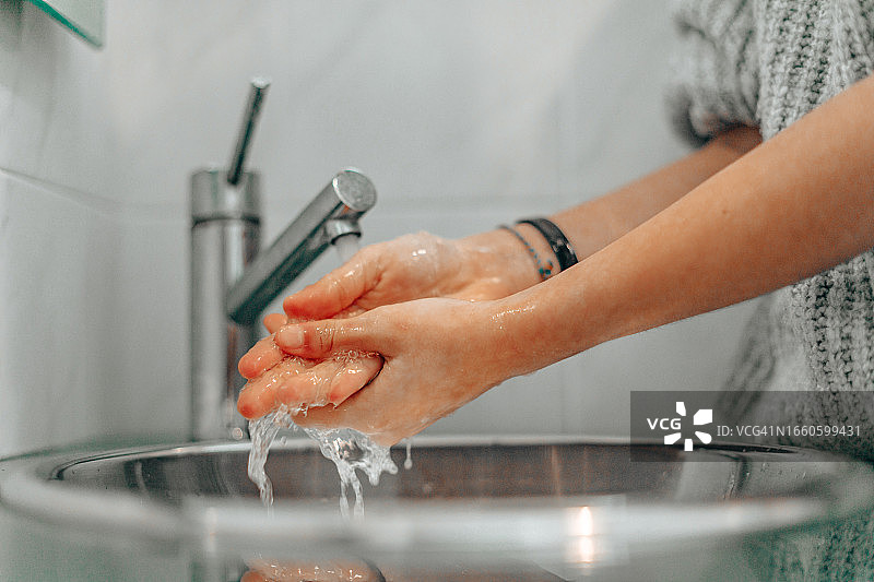 剪短的女性在浴室洗手的图片图片素材