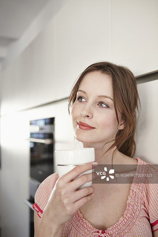 在厨房里享受咖啡的女人图片素材