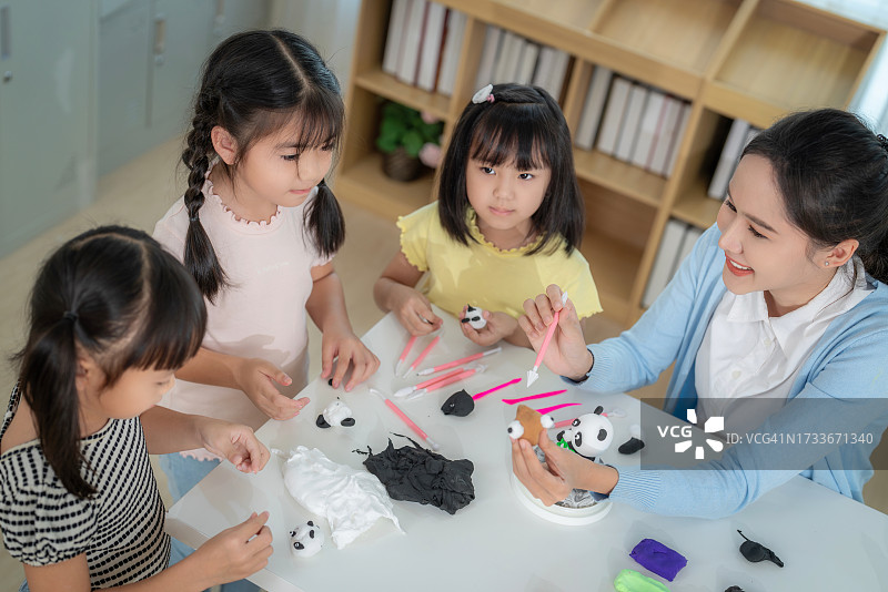 亚裔老师和她的小学生在彩陶模塑课上图片素材