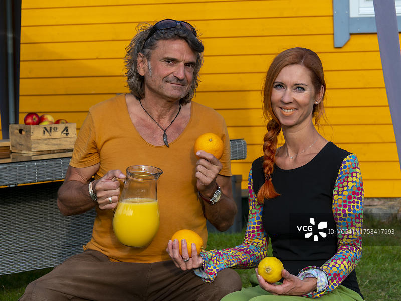 男士和女士奉上新鲜的果汁，搭配果汁和水果，产自德国图片素材