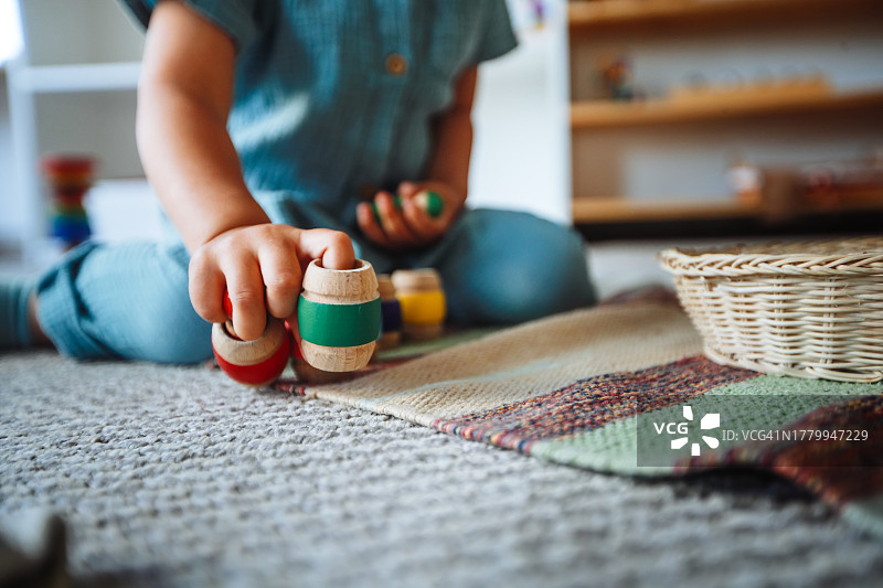 蒙台梭利游戏时间:韩国幼儿在地板上玩木桶玩具，促进早期发育。关闭并复制空间图片素材