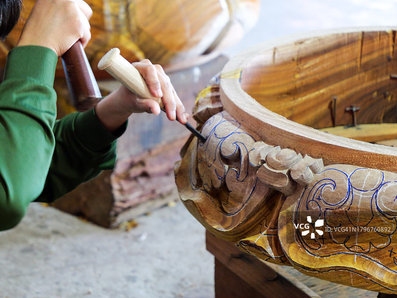 在泰国芭堤雅佛寺的工坊里，工匠在雕刻木雕雕像图片素材