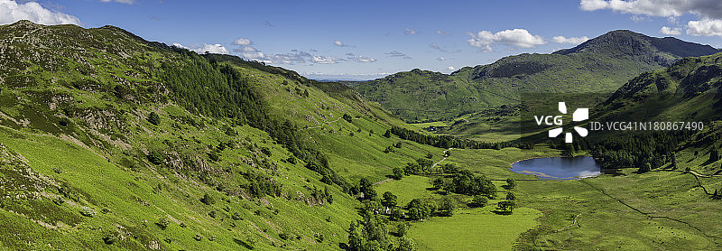 宁静的夏季山谷全景，田园诗般的山峰在绿色的景观图片素材