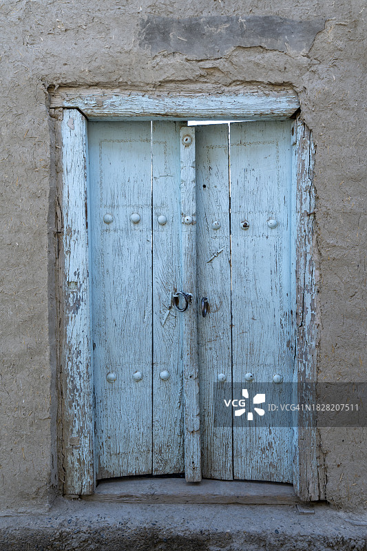 石墙上的一扇古色古香的蓝色门。古代建筑图片素材